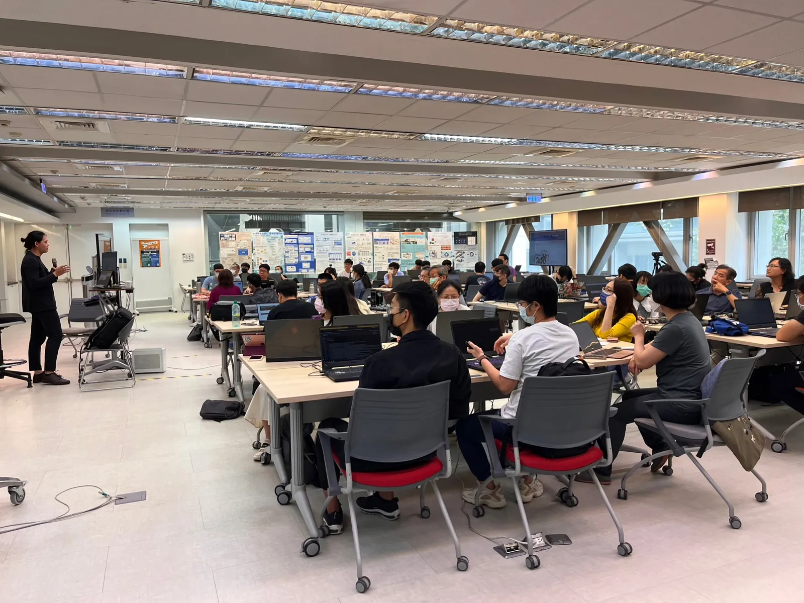 A computer classroom at Feng Chia University: I stand on the left with a microphone while participants sit at their laptops